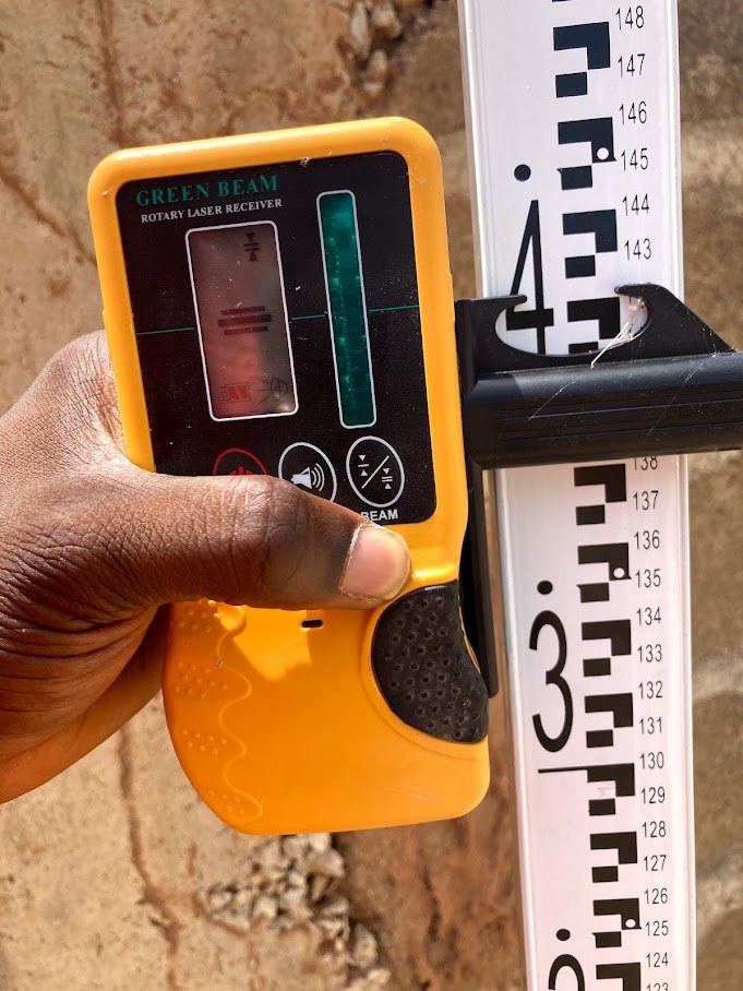 Engineer using a laser level receiver for precision measurement on a Punctum Construction site