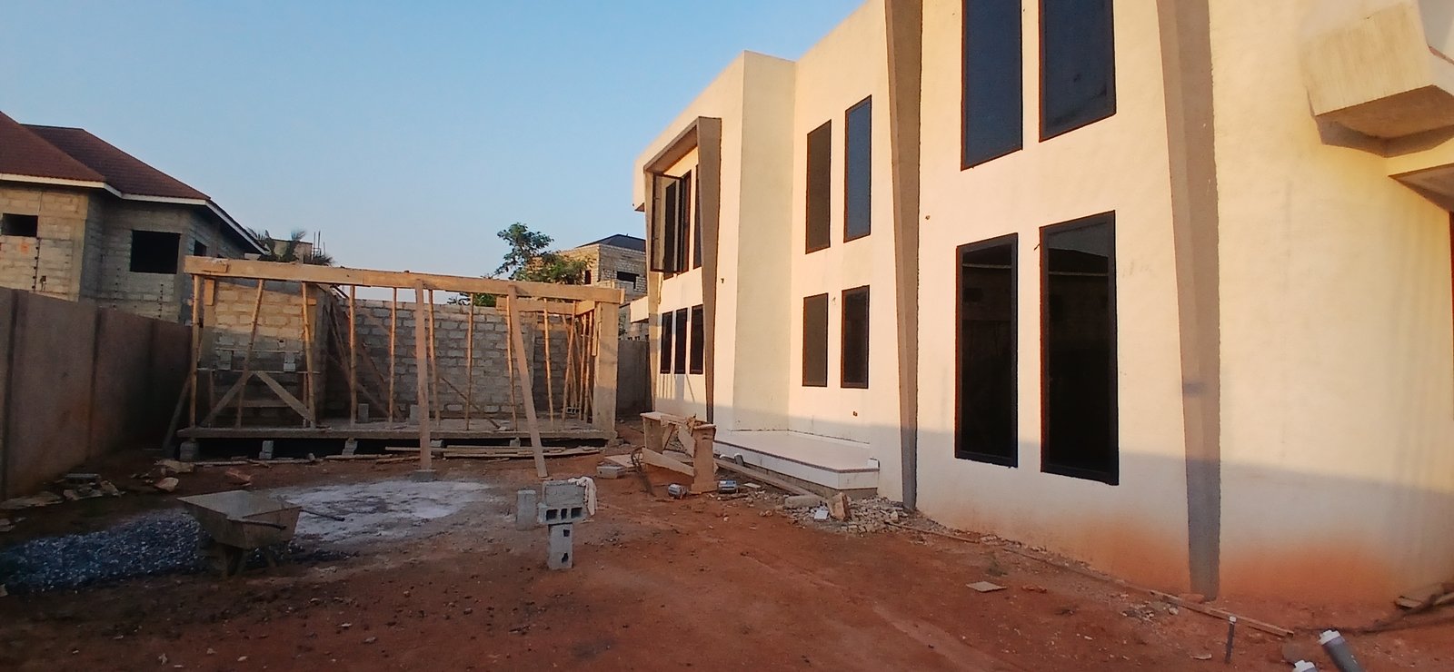 Concrete mixer and crew at work during pool house construction at East Legon Hills, Accra